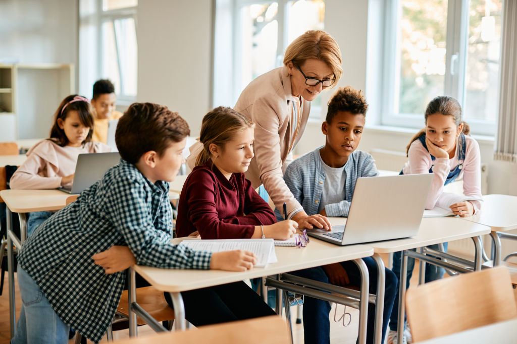 Students collaborating around a laptop